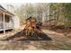 Spacious backyard showcasing a wooden playset nestled amongst mature trees offering ample space for outdoor play at 31 Wyngate Ct, Dallas, GA 30157