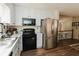 Well-lit kitchen features white cabinets, stainless steel refrigerator, and modern black oven at 31 Wyngate Ct, Dallas, GA 30157