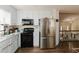 Inviting kitchen shows stainless steel refrigerator, black oven, and updated white cabinets at 31 Wyngate Ct, Dallas, GA 30157
