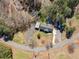 An aerial view showcases the house with a black roof and white walls, along with the surrounding landscape and road at 4885 Pisgah Rd, Cumming, GA 30028