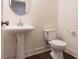 Powder room with a pedestal sink, decorative mirror and modern toilet with sleek design elements at 5316 Radford Loop, Fairburn, GA 30213