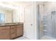 Bathroom featuring a shower with marble tile, vanity with double sinks, and wood cabinets at 5316 Radford Loop, Fairburn, GA 30213
