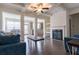 Open-concept living room with dark floors, fireplace, coffered ceilings, and large windows at 5316 Radford Loop, Fairburn, GA 30213