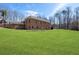 Large grassy backyard with a brick home, mature trees, and a private setting at 644 Herring Rd, Grayson, GA 30017