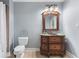 Bathroom with a wooden vanity, marble countertop, decorative mirror, toilet and walk-in shower at 644 Herring Rd, Grayson, GA 30017