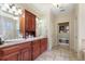 Bathroom with dual sinks, soaking tub, travertine floors, and natural light at 644 Herring Rd, Grayson, GA 30017