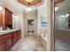 Bathroom with dual sinks, soaking tub, travertine floors, and natural light at 644 Herring Rd, Grayson, GA 30017