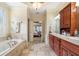 Bathroom with dual sinks, soaking tub, travertine floors, and natural light at 644 Herring Rd, Grayson, GA 30017