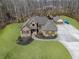 Beautiful home exterior with well-maintained landscaping, a long driveway, and a three-car garage, surrounded by mature trees at 644 Herring Rd, Grayson, GA 30017