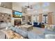 Sophisticated living room featuring a stone fireplace, built-in shelving, vaulted ceiling, and plush blue sofas at 644 Herring Rd, Grayson, GA 30017