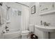 Bright bathroom with white subway tiles, a pedestal sink, and a shower-tub combo at 2711 Winding Ne Ln, Brookhaven, GA 30319