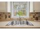 Close-up of kitchen sink with stainless steel faucet and view of backyard trees through window at 2711 Winding Ne Ln, Brookhaven, GA 30319