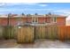 The backyard has a wood fence for privacy, and red brick townhomes are shown beyond the fence at 6105 Queen Anne Ct, Norcross, GA 30093