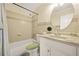 Cozy bathroom features a tiled shower and tub combination with a white vanity and round mirror at 6105 Queen Anne Ct, Norcross, GA 30093