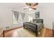 This cozy bedroom features a fan, warm lighting, and a view out the large windows at 6105 Queen Anne Ct, Norcross, GA 30093