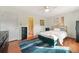 Bright bedroom boasts wood floors, ceiling fan, accent wall art, and a view into the bathroom at 6105 Queen Anne Ct, Norcross, GA 30093