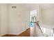 Upstairs hallway featuring wood floors and view into a sunlit living room at 6105 Queen Anne Ct, Norcross, GA 30093