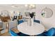 Bright dining area featuring a modern round table with elegant blue chairs, next to an open-concept kitchen and living area at 1328 Magnolia Bend Way # 305, Jonesboro, GA 30238