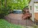 Fenced backyard featuring a wooded area, deck, stairs, and a covered structure with a lush, green ground covering at 31 Greenland Trce, Atlanta, GA 30342