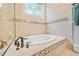 Luxurious soaking tub with elegant fixtures and tile surround at 31 Greenland Trce, Atlanta, GA 30342