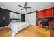 Charming bedroom featuring a ceiling fan, hardwood floors, and built-in shelving and desk for workspace at 31 Greenland Trce, Atlanta, GA 30342