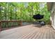 Large deck with wood flooring, black railings, and furniture set overlooking trees at 31 Greenland Trce, Atlanta, GA 30342