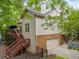 Back exterior view with wood siding, brick base, wood deck, and multi-car garage at 31 Greenland Trce, Atlanta, GA 30342