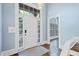 Bright foyer with hardwood floors, white door with glass sidelights, and soft blue walls at 31 Greenland Trce, Atlanta, GA 30342