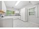 Bright laundry room with white cabinetry, countertops, and tile flooring at 31 Greenland Trce, Atlanta, GA 30342