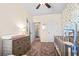 Bedroom with nature themed wallpaper, crib, changing table, and ceiling fan at 315 Skye Ln # 50, Cartersville, GA 30121