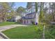 Scenic view of a two-story home nestled amongst mature trees and a lush green lawn at 5338 Timor Trl, Lithonia, GA 30038