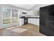 Bright kitchen featuring white cabinets, black appliances, and tile flooring at 5338 Timor Trl, Lithonia, GA 30038