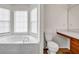 Bathroom with a soaking tub under a window, a toilet, and a sink vanity at 114 Belmonte Sw Dr, Atlanta, GA 30311