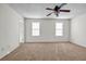 Spacious bedroom with neutral carpet, ceiling fan, and natural light from two windows at 114 Belmonte Sw Dr, Atlanta, GA 30311