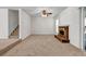 Bright living room with cozy fireplace and plush carpet next to a staircase at 114 Belmonte Sw Dr, Atlanta, GA 30311