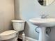 Neat powder room featuring a pedestal sink, toilet, and neutral color scheme at 2124 Silas Nw Way, Atlanta, GA 30318