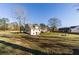 Expansive backyard with mature trees, a seating area, and a view of the home's rear exterior at 770 Winding Creek Trl, Dacula, GA 30019