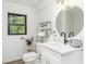 Bathroom featuring modern fixtures, natural light, and a round mirror at 770 Winding Creek Trl, Dacula, GA 30019