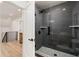 Bathroom featuring a glass enclosed shower with gray tiles, modern fixtures, and bright hardwood flooring at 770 Winding Creek Trl, Dacula, GA 30019