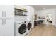 Well-organized laundry room with modern washer and dryer, storage cabinets, and a desk area at 770 Winding Creek Trl, Dacula, GA 30019