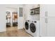 Modern laundry room with shelving, cabinetry, and a doorway leading to an organized entryway at 770 Winding Creek Trl, Dacula, GA 30019