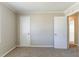 Bedroom with neutral colored walls and carpet; doors leading to other rooms at 774 Marthas Dr, Lawrenceville, GA 30045