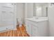 Bright bathroom featuring a shower, white vanity, and wood-look flooring at 2664 Homeland Dr, Atlanta, GA 30360