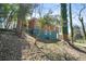 Rear exterior view showcasing a two-story brick home with teal siding and mature trees at 2664 Homeland Dr, Atlanta, GA 30360