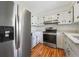 Charming kitchen with stainless steel appliances, white cabinets, and wood-look flooring at 2664 Homeland Dr, Atlanta, GA 30360