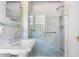 Bathroom with pedestal sink, frameless glass shower, and marble tile at 401 Peachtree Battle Nw Ave, Atlanta, GA 30305