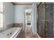 Elegant bathroom with a soaking tub, glass shower, and a luxurious marble countertop and floors at 401 Peachtree Battle Nw Ave, Atlanta, GA 30305