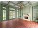 Stylish bonus room with brick floors, fireplace, coffered ceilings, and verdant green trim at 401 Peachtree Battle Nw Ave, Atlanta, GA 30305