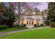 Elegant two-story white home with a red tile roof, manicured lawn, and beautiful landscaping at 401 Peachtree Battle Nw Ave, Atlanta, GA 30305