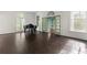 Bright living room with dark hardwood floors, piano, and arched windows for natural light at 401 Peachtree Battle Nw Ave, Atlanta, GA 30305